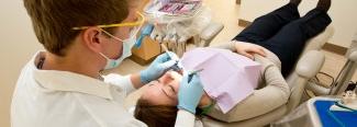 a dental student works on a patient