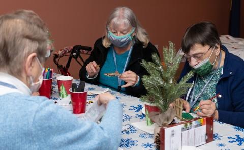 People paint holiday-themed crafts at a wellness fair for Westbrook Housing residents